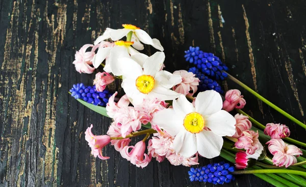 Bouquet de fleurs printanières colorées sur une table en bois — Photo