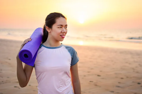 Szczęśliwa dziewczyna z matę do jogi na plaży — Zdjęcie stockowe