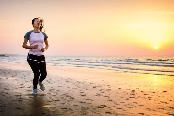 Mädchen läuft bei Sonnenuntergang am Strand — Stockfoto