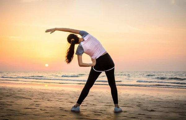 Mädchen beim Sport am Strand bei Sonnenuntergang — Stockfoto