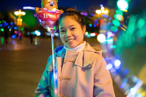 Счастливая девушка с освещенными воздушными шарами снаружи — стоковое фото