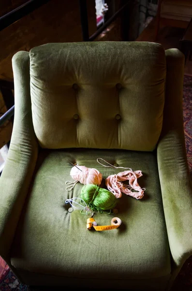 Crocheting tools on a green sofa chair — Stock Photo, Image