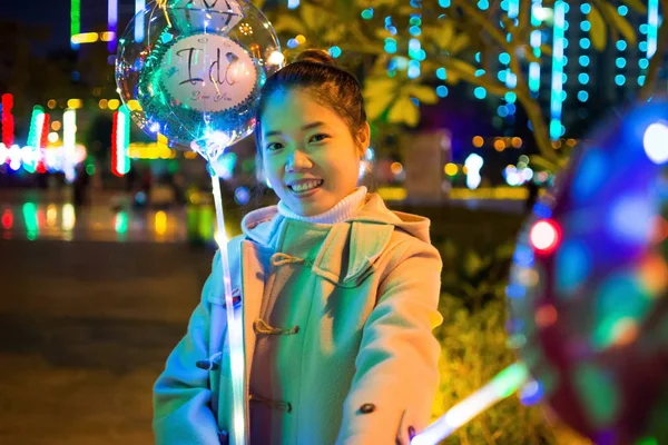 Щаслива дівчина з освітленими повітряними кулями зовні — стокове фото
