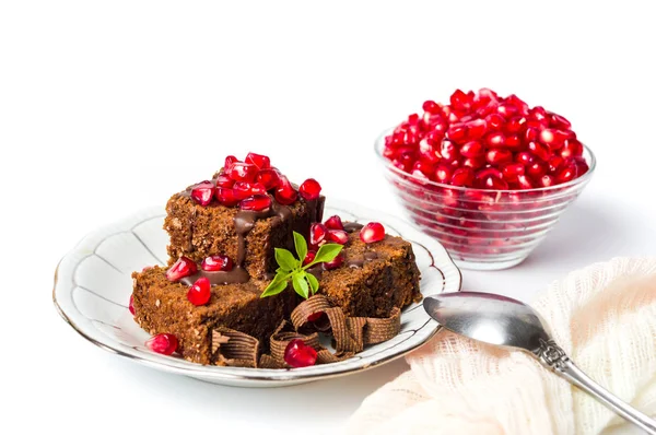 Chocolate cake with pomegranate on a plate — Stock Photo, Image