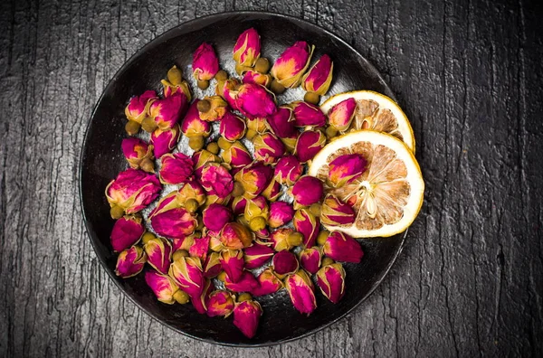 Brotes de té rosa en plato oscuro — Foto de Stock