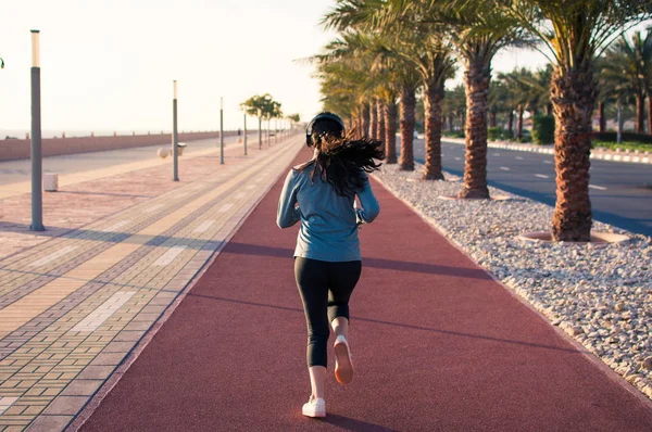 Dziewczyna, bieganie na bieżni przez morze — Zdjęcie stockowe