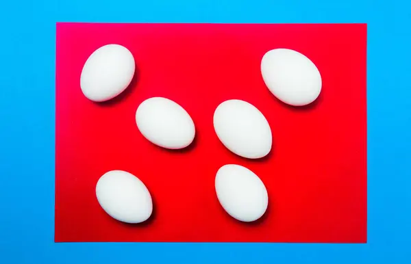 Weiße Eier auf rotem Hintergrund von oben — Stockfoto