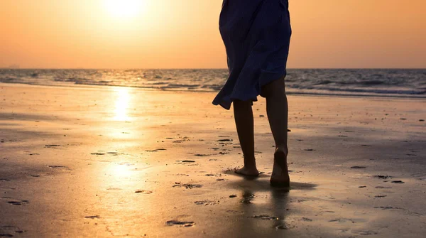 Girl walking on the beach at sunset — Stock Photo, Image