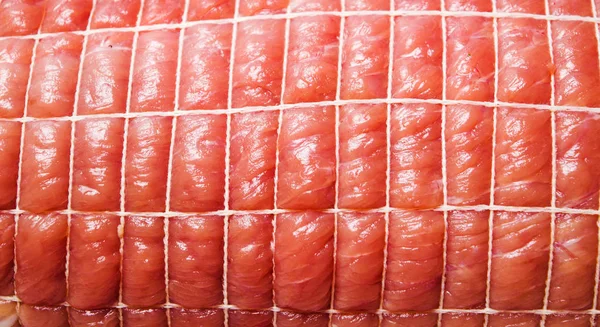 Мясо сырой свинины в сетке крупным планом — стоковое фото