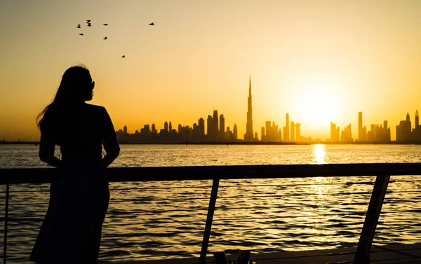 Mujer frente a vista panorámica de Dubai al atardecer —  Fotos de Stock