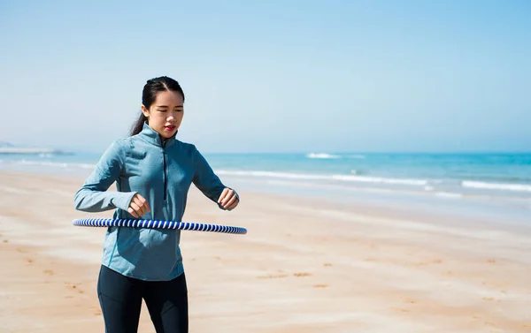 Mädchen übt mit Hula-Hoop-Reifen am Strand — Stockfoto