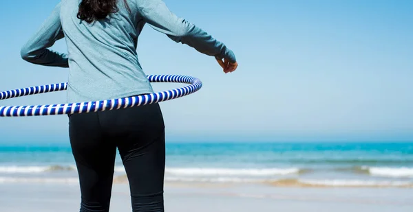 Mädchen übt mit Hula-Hoop-Reifen am Strand — Stockfoto