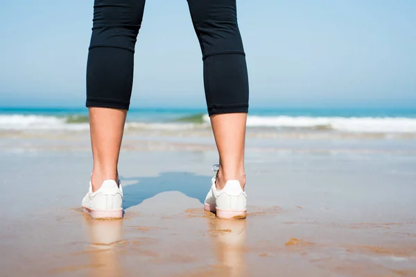 Närbild av en kvinnlig jogger på stranden — Stockfoto