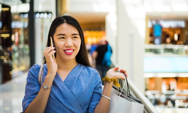 Menina usando telefone ao fazer compras — Fotografia de Stock