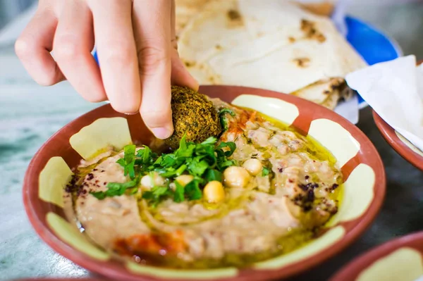 Mujer comiendo felafel y hummus con frijoles —  Fotos de Stock