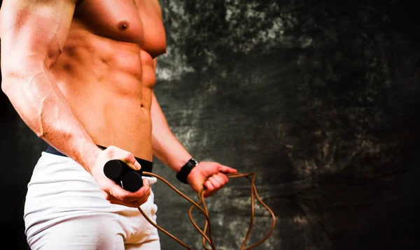 Bodybuilder holding a jumping rope — Stock Photo, Image