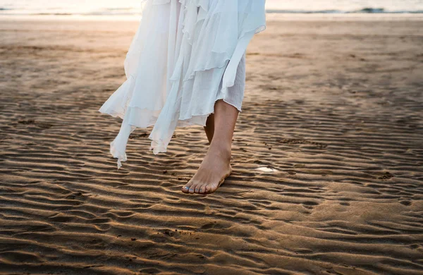Chica en vestido blanco caminando por la playa — Foto de Stock