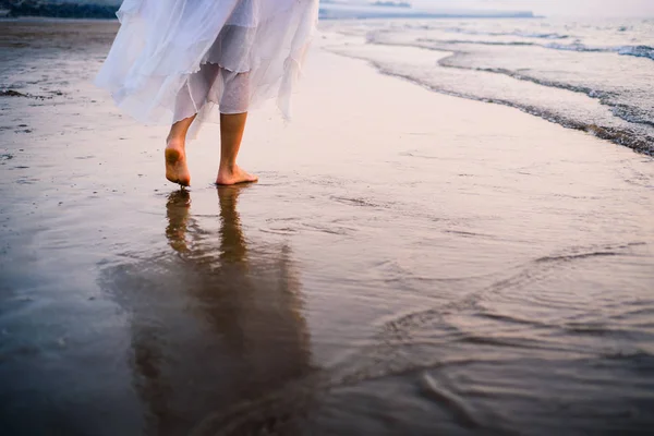 Ragazza che cammina sulla spiaggia vestita di bianco — Foto Stock