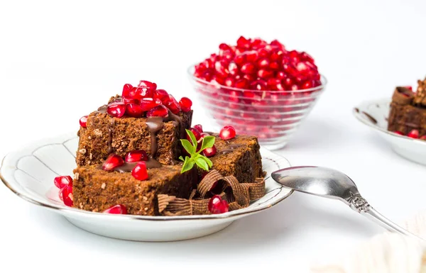 Chocolate cake with pomegranate on a plate — Stock Photo, Image