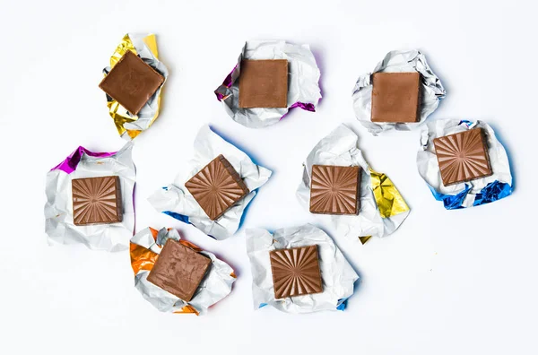 Piezas de chocolate en papel de aluminio aislado — Foto de Stock