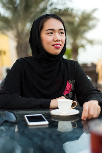 Muslimische Frau in einem Café im Freien — Stockfoto