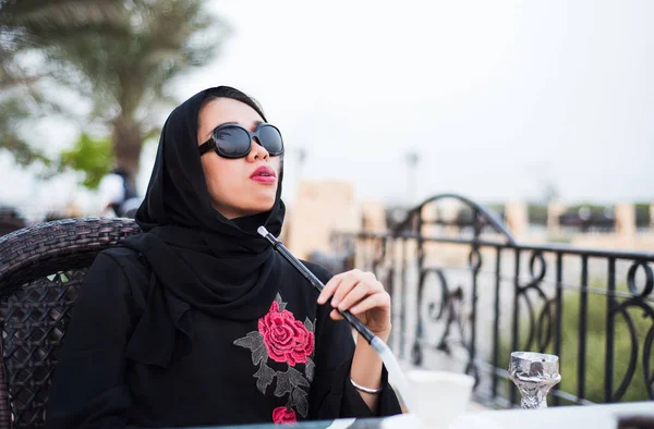 Мусульманская женщина курит шишу на открытом воздухе — стоковое фото