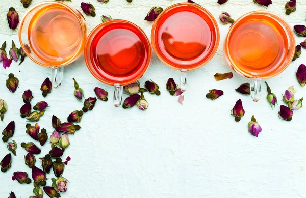 Chá rosa e pétalas de flores no fundo branco — Fotografia de Stock