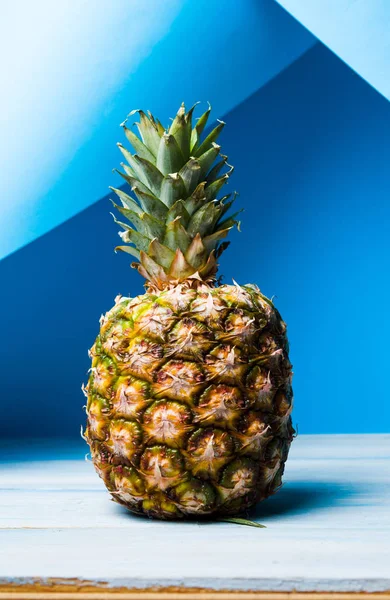 Hele ananas tegen blauwe achtergrond — Stockfoto