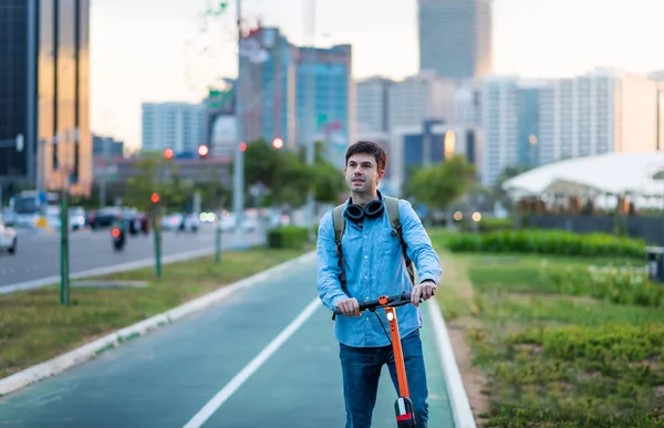 Hombre usando scooter eléctrico para el transporte en una ciudad moderna — Foto de Stock