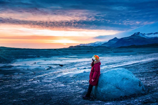 Žena kráčející po islandském ledovcovém povrchu a užívající si západ slunce — Stock fotografie
