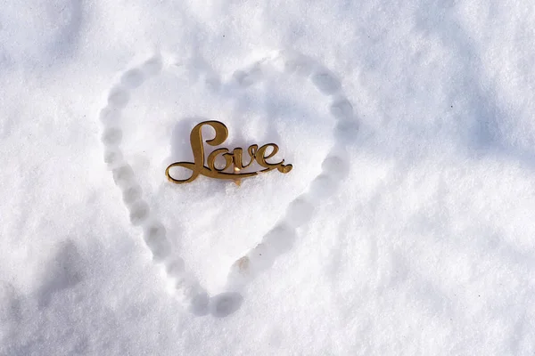 Amor escrito en la nieve con símbolo del corazón — Foto de Stock