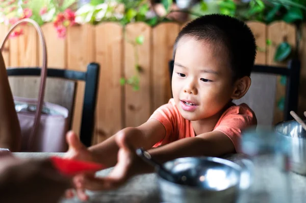 Bambino cinese che riceve una tasca rossa sul tavolo — Foto Stock