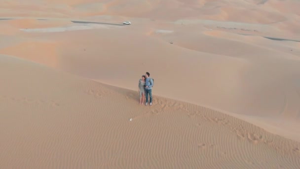 砂漠の空中風景の中でロマンチックな景色の夕日を楽しむカップル — ストック動画