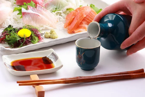 Japonské rýžové víno saké a talíř s variací Sashimi, japonské jídlo — Stock fotografie