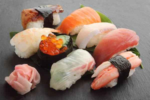 Gemischte Sushi-Platte auf schwarzem Steinteller, japanisches Essen — Stockfoto