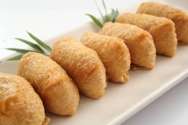 Beyaz arka plan, Japon yemekleri üzerine kızarmış Tofu Inari suşi sarılı