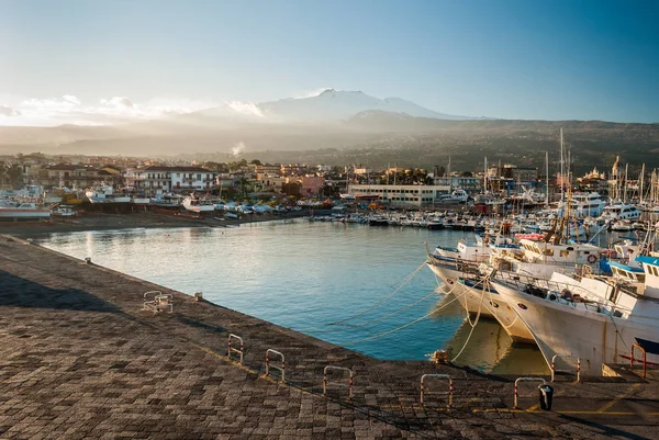 The harbor of Riposto during the sunset; snowy volcano Etna in the background — Stock Photo, Image