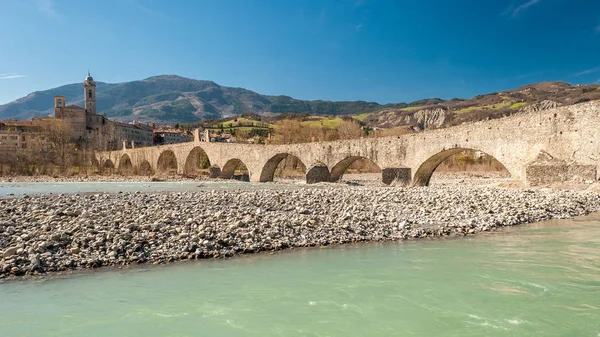 Pohled na starý středověký most, nazývaný "Ponte del Diavolo" nebo "Ponte Gobbo" nad řekou Trebbia v malém městě Bobbio (severní Itálie) — Stock fotografie