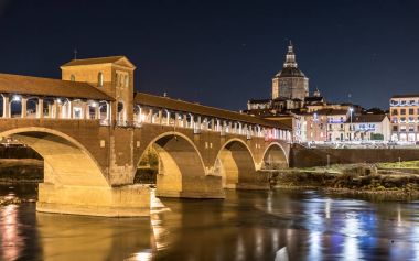 Pavia Ponte Coperto ve nehrin Ticino gece görünümü