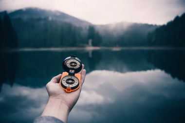 Dağ gölü arka plan üzerinde el ele tutuşarak pusula