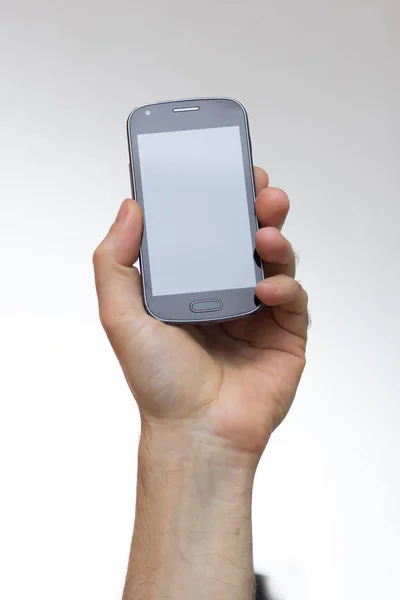 Smartphone em uma mão estendida — Fotografia de Stock