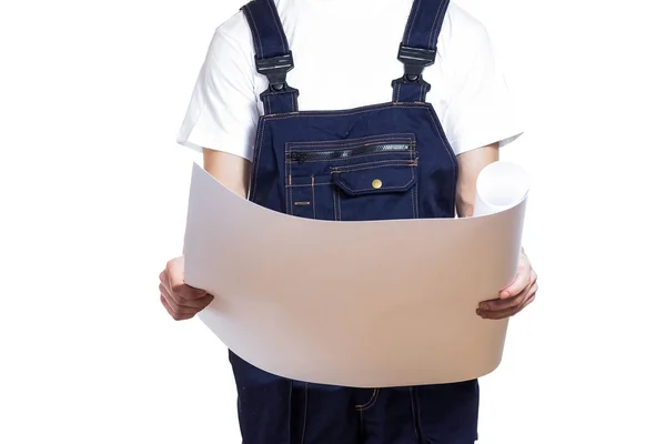 A man in overalls is studying a drawing — Stock Photo, Image