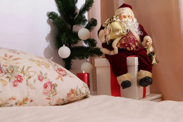 クリスマスに、サンタクロースは隣のベッドの近くの贈り物で座っています。 — ストック写真