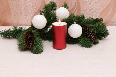 Noel ağacı süslemeleri ile yanan kırmızı mum.