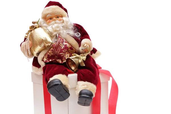 Santa Claus está sentado en una mano sosteniendo una moneda en su mano . — Foto de Stock