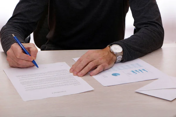 Un hombre de negocios firma un contrato y da dinero en efectivo . — Foto de Stock