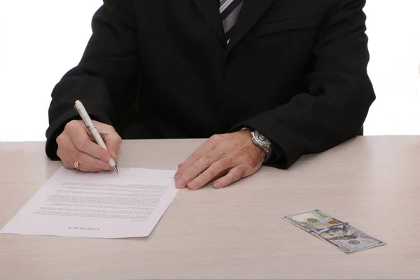 Un hombre de negocios firma un contrato y da dinero en efectivo . — Foto de Stock