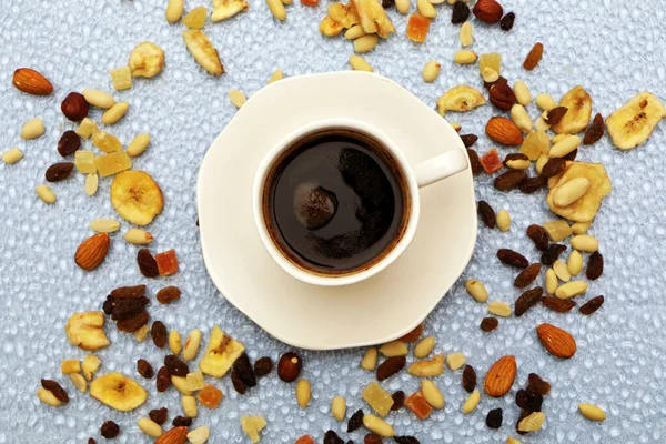 På bordet finns en kopp kaffe och nötter utspridda. — Stockfoto