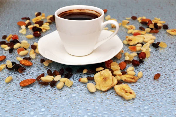På bordet finns en kopp kaffe och nötter utspridda. — Stockfoto