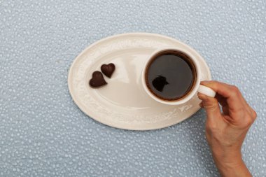 Bir fincan kahve el tutar.